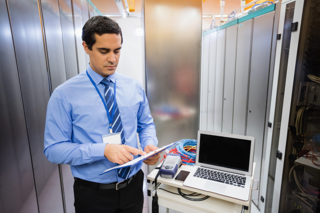 Calm access & compliance checklist in network cabinet Clipboard with access and compliance checklist in a tidy network cabinet.