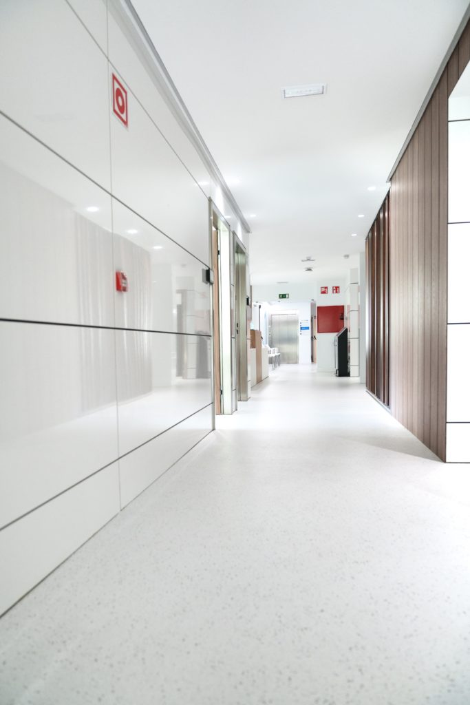 Healthcare clinic corridor for managed IT support Clean medical clinic corridor with soft lighting and no patients.