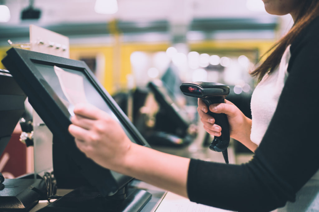 POS printer maintenance to avoid interruptions — Divine Logic Hands service a receipt printer at a POS counter to keep checkout devices reliable.