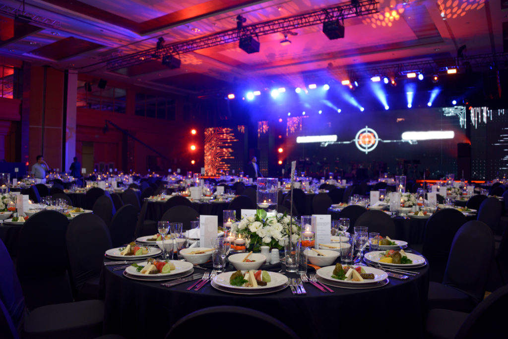 On-site AV technician soundchecks mixer for hotel event AV technician in dress shirt and tie soundchecks mixer in hotel ballroom.