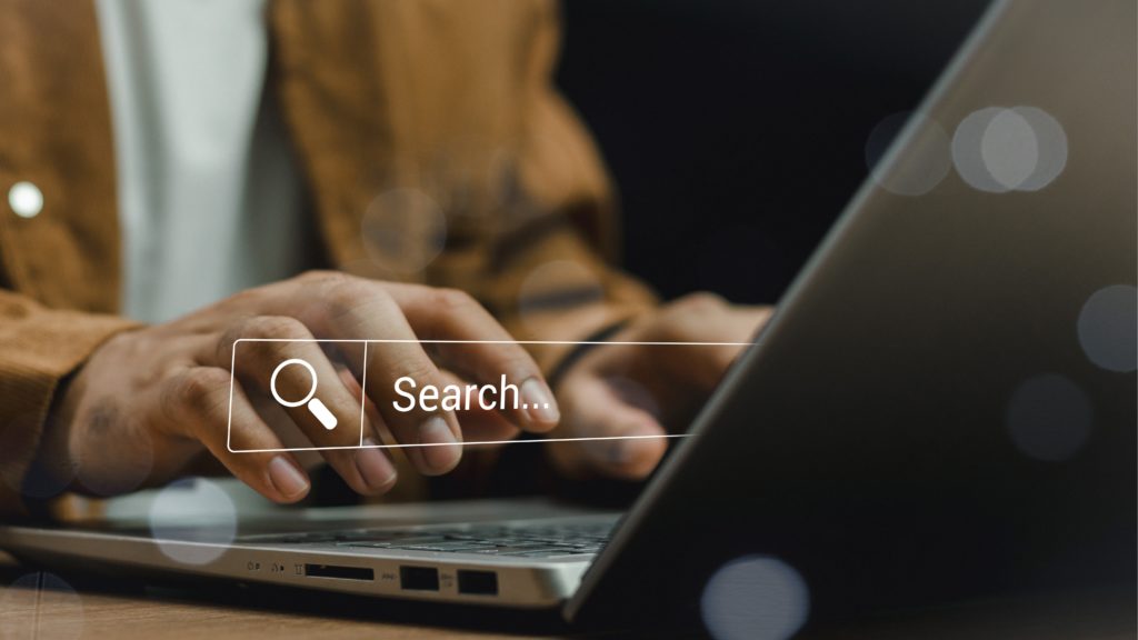 Updating local business details for consistency Hands update business profile fields on a laptop in a neutral office.