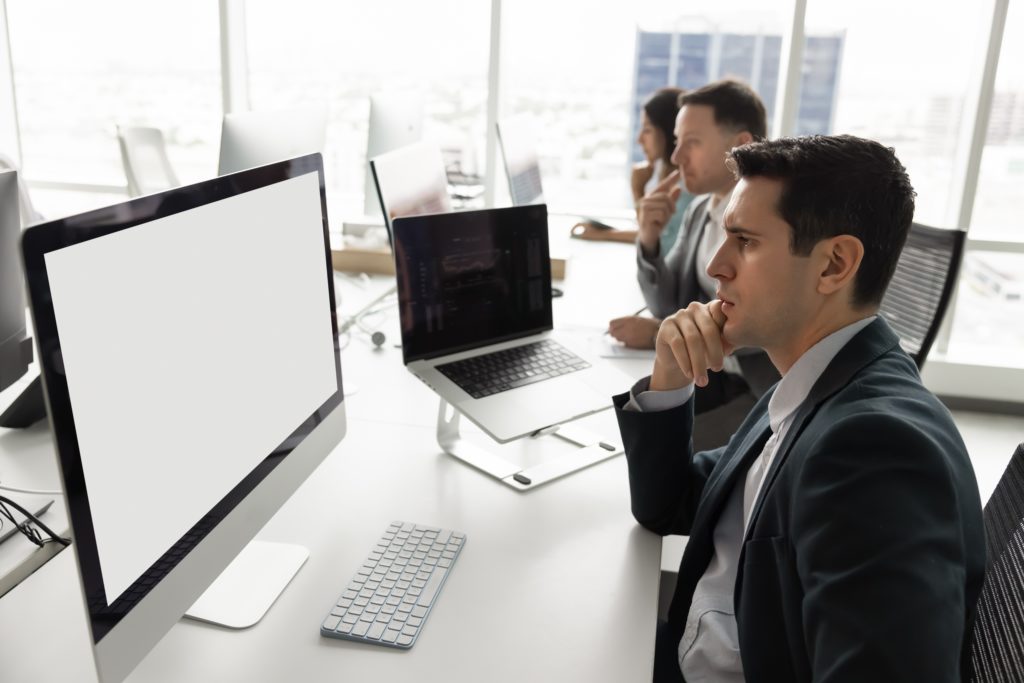Divine Logic vCIO discovery for Fresno small businesses Small-business owners review an IT plan with a consultant in a modern office.