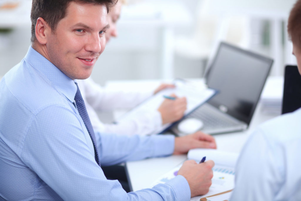 IT technician in dress shirt and tie consulting with small business owner in Fresno office
